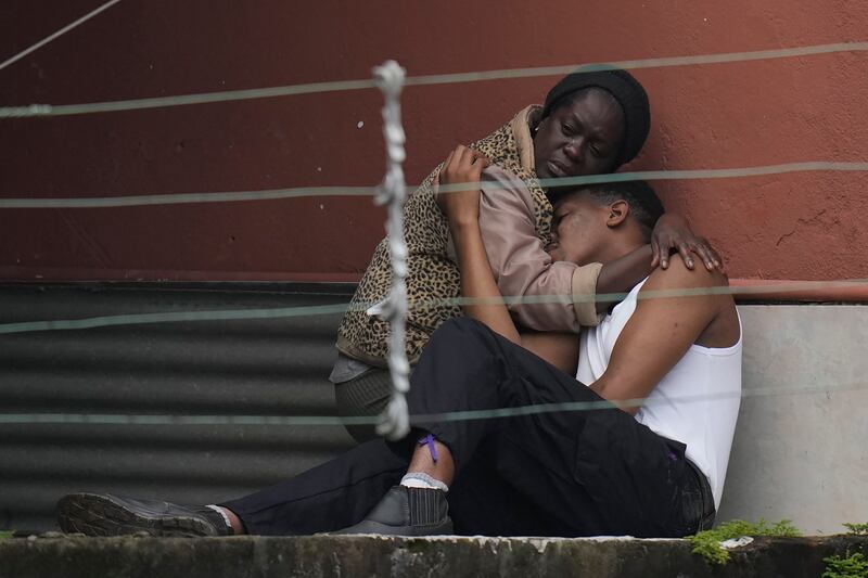 Residents embrace after fatal mudslides destroyed homes in Petropolis. AP