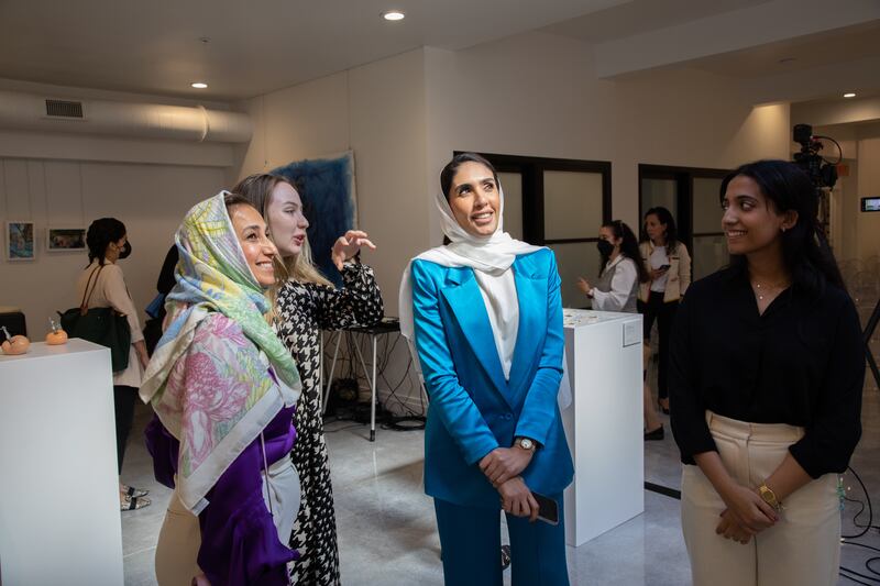 Visitors and artists admire the works on display.