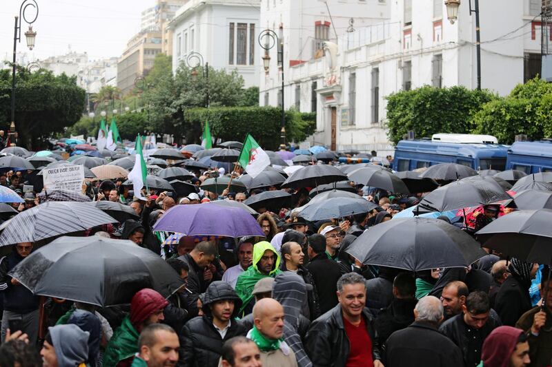 Demonstrators march under heavy rain during a protest against the country's ruling elite and rejecting the December presidential election in Algiers, Algeria. Reuters