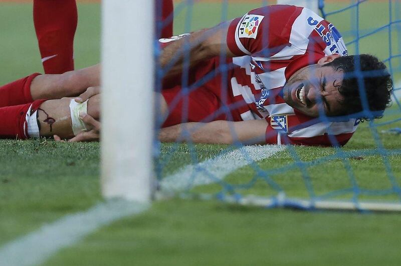 Atletico's Diego Costa holds his leg as he got injured after scoring during a Spanish Primera Liga match between Getafe and Atletico Madrid at the Coliseum Alfonso Perez stadium in Madrid, Spain, Sunday, April 13, 2014. AP Photo/Andres Kudacki
