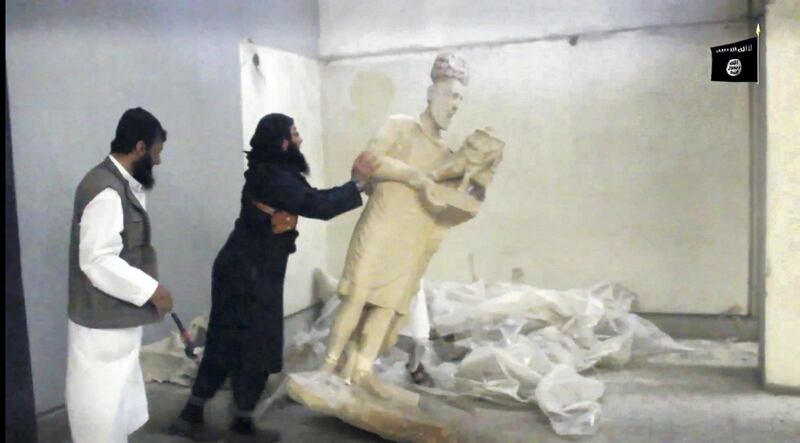 An image grab taken off a video reportedly released by Media Office of the Nineveh branch of the Islamic State (IS) Group on February 26, 2015, allegedly shows an IS militant pushing a statue inside the Mosul museum in the northern Iraqi Governorate of Nineveh. The five-minute video shows IS militants knocking statues off their plinths in the Mosul museum and smashing them to pieces with sledgehammers. AFP PHOTO / HO / Media Office of the Nineveh branch
== RESTRICTED TO EDITORIAL USE - MANDATORY CREDIT "AFP PHOTO / HO / Media Office of the Nineveh branch" - NO MARKETING NO ADVERTISING CAMPAIGNS - DISTRIBUTED AS A SERVICE TO CLIENTS FROM ALTERNATIVE SOURCES, AFP IS NOT RESPONSIBLE FOR ANY DIGITAL ALTERATIONS TO THE PICTURE'S EDITORIAL CONTENT, DATE AND LOCATION WHICH CANNOT BE INDEPENDENTLY VERIFIED == (Photo by - / Welayat Nineveh Media Office / AFP)