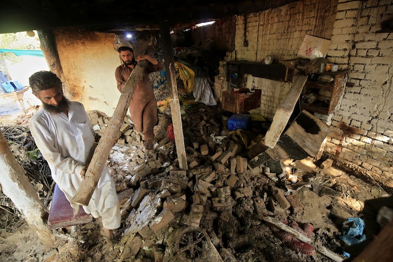 People assess the damage to their home in Nowshera. EPA