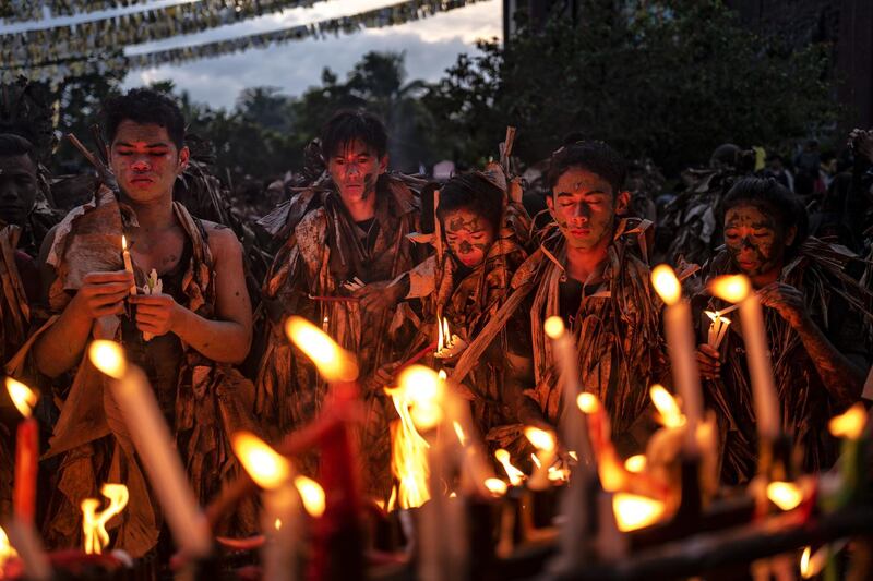 ALIAGA, PHILIPPINES - JUNE 24: Devotees covered in mud and dried banana leaves light candles as they take part in the Taong Putik ("mud people") Festival on June 24, 2019 in the village of Bibiclat in Aliaga town, Nueva Ecija province, Philippines. Each year, the residents of Bibiclat village in Aliaga town celebrate the Feast of Saint John by covering themselves in mud, dried banana leaves, vines, and twigs as part of a little-known Catholic festival. According to locals, the Taong Putik festival (literally meaning "mud people festival"), traces its history from the Pacific War and reenacts how rain stopped the execution of 14 villagers by Japanese soldiers in 1944. The townsfolk considered this as a miracle from Saint John, and every year since then the villagers roll in mud to show their gratitude to the saint. The Feast Day of Saint John the Baptist is celebrated throughout the country every June 24. The Philippines is the only Southeast Asian country with a predominantly Catholic majority. (Photo by Ezra Acayan/Getty Images)