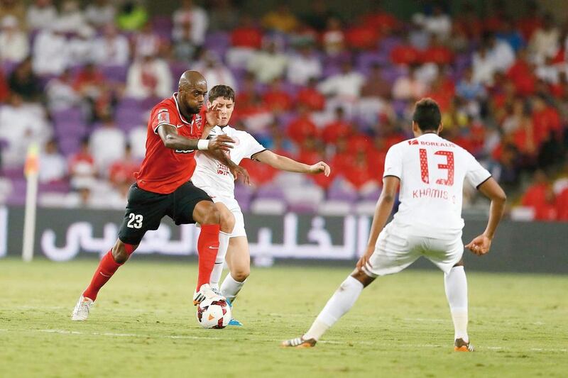 Al Ahli's Grafite holds off Al Jazira's Abdelaziz Barrada as Khamis Esmail moves to block his patch during the Arabian Gulf Cup final at Hazza bin Zayed Stadium on April 19, 2014. Grafite hit the equaliser for Ahli at the 69th minute. Al Ittihad