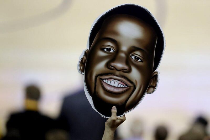 A fan holds up a Draymond Green face on Tuesday at Game 5 of the NBA Finals, where the Golden State Warriors forward was suspended from playing. Ronald Martinez / Getty Images / AFP / June 13, 2016 