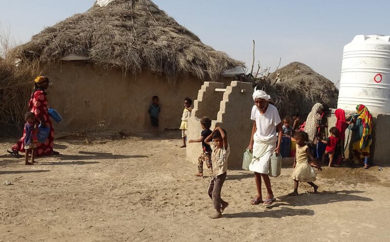 Yemenis fill their jerrycans with water at a make-shift camp for the internally displaced, in Yemen's war-ravaged western province of Hodeida on April 17, 2021, amid a severe shortage of water. (Photo by Khaled Ziad / AFP)