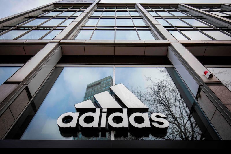 (FILES) In this file photo taken on March 29, 2020, the logo of German sporting goods company Adidas is pictured at one of the company's outlets in Berlin.  Adidas has obtained the German government's approval on April 14, 2020 for an emergency loan of €3 billion in total, including €2.4 billion from the state-owned KfW bank, to respond to the "severe impact" of the coronavirus pandemic. / AFP / Odd ANDERSEN

