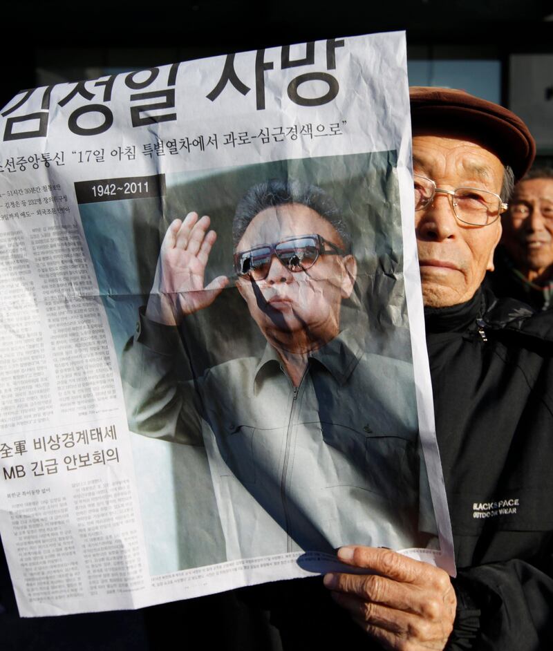 An elderly South Korean man from a conservative, right-wing and anti-North Korean civic group, holds an extra edition of a local newspaper reporting the death of North Korean leader Kim jong-il at a rally in Seoul December 19, 2011. North Korean leader Kim Jong-il died on a train trip, state television reported on Monday sparking immediate concern over who is in control of the reclusive state and its nuclear programme. A tearful announcer dressed in black said the 69-year old had died on December 17, 2011 of physical and mental over-work on his way to give "field guidance". REUTERS/Lee Jae-Won (SOUTH KOREA - Tags: POLITICS OBITUARY) *** Local Caption ***  SEO12_KOREA-NORTH-_1219_11.JPG