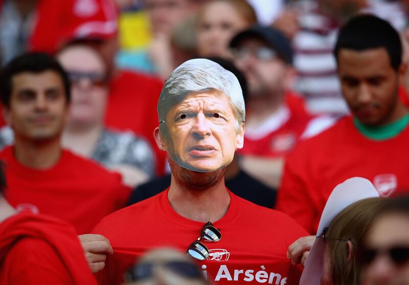 Arsenal fans are seen wearing Arsene Wenger face masks. Clive Mason / Getty Images