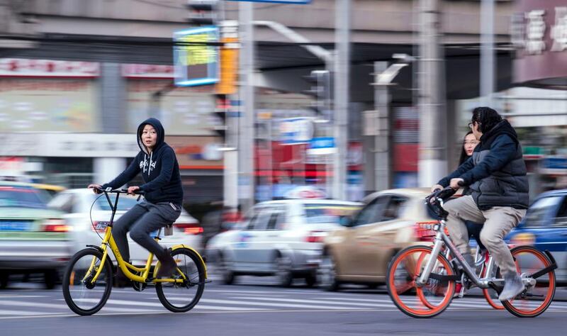 Brightly-coloured two-wheelers such as those from Ofo, left, and Mobike, right, are encouraging Chinese commuters to bike-share and cut down the country's urban congestion and pollution. Johannes Eisele / AFP 