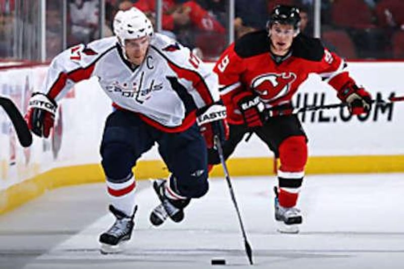 Chris Clark of the Washington Capitals skates against Zach Parise of the New Jersey Devils during Saturday's game.
