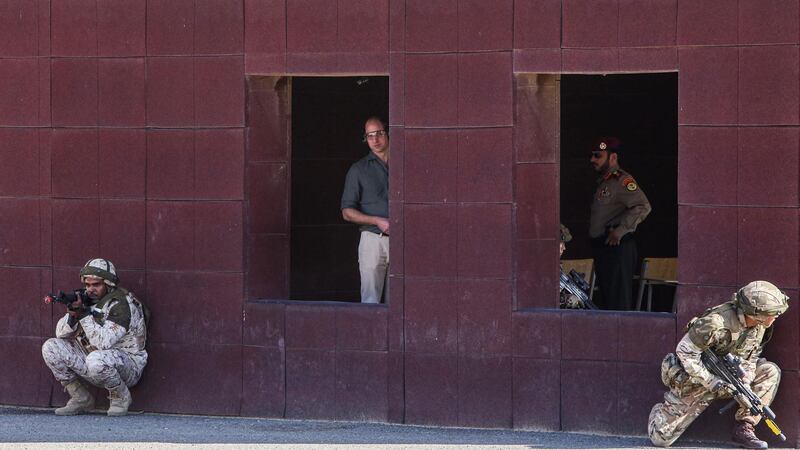 Prince William (C), Duke of Cambridge, looks on from the window of a building as Kuwaiti and British soldiers outside take part in the Exercise Desert Warrior at Sheikh Salem al-Ali al-Sabah Camp, about 40 kilometres north of Kuwait City. AFP