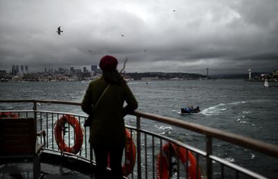 A woman looks at the Bosphorus from the terrace of a ferry as she travels from Europe to Asia during a storm in Istanbul on November 28, 2018. / AFP / BULENT KILIC
