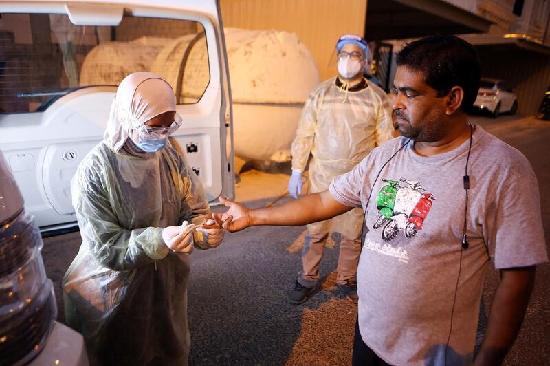 A Kuwaiti health ministry worker conducts a random test for the coronavirus in Kuwait City. AFP