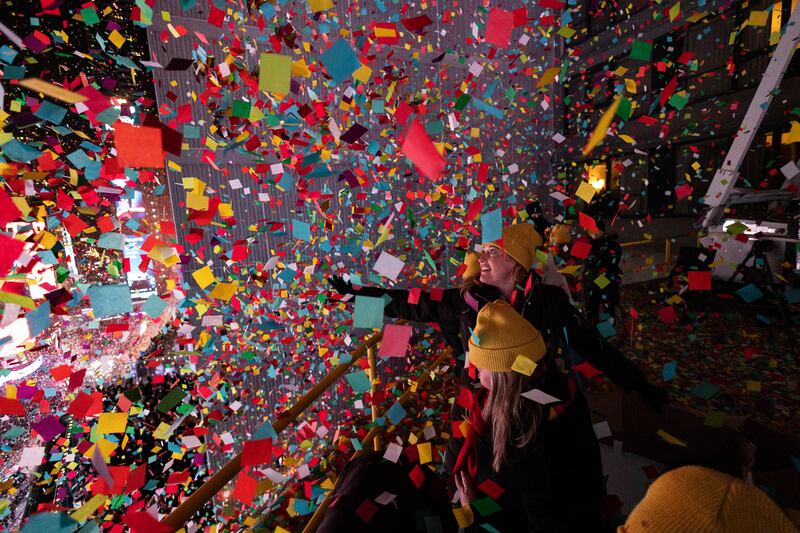 Times Square Alliance volunteers throw confetti as the clock strikes midnight during the New Year's Eve celebration in New York.  AP
