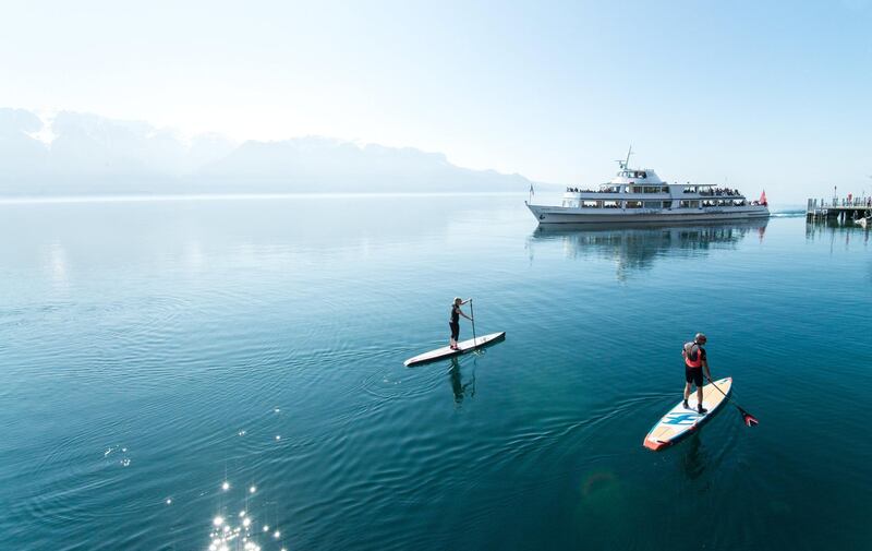 Summer weather in Switzerland is perfect for outdoor activities like paddle boarding on the lake. Courtesy Vaud Tourism / Maude Rion