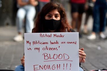 An anti-government protester carries a placard near the site where a Lebanese man Ali Al-Hok killed himself at Hamra Street in Beirut, Lebanon on 03 July 2020. EPA