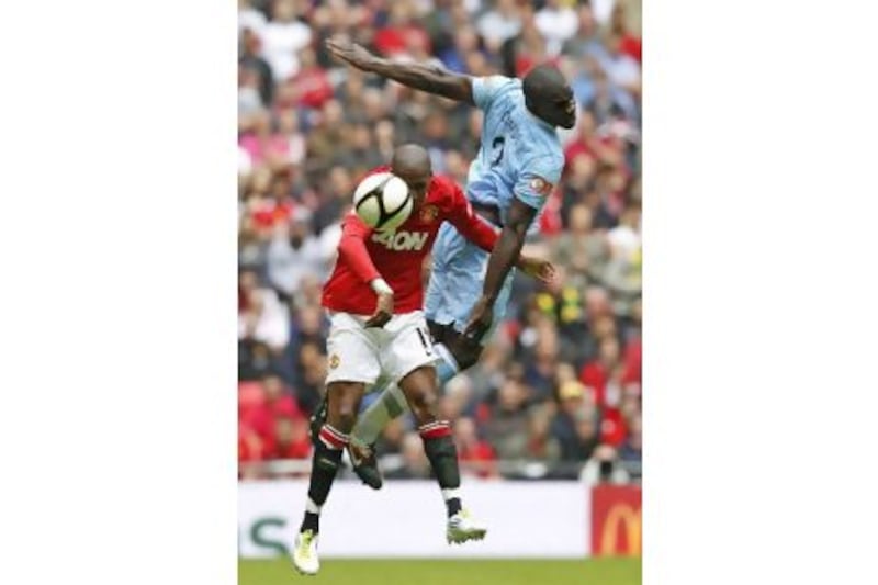 Manchester United's Ashley Young and Manchester City's Micah Richards duel for the aerial ball at Wembley Stadium.