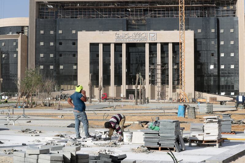 Egyptian workers at a construction site in front of the new National Bank building in the new capital.