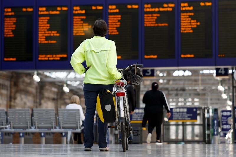 Passengers check on the status of their trains at Glasgow Central station in Scotland. Getty Images