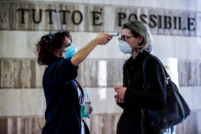 A woman has her temperature checked at the entrance of the IFO Regina Elena and San Gallicano hospital in Rome, Italy. EPA