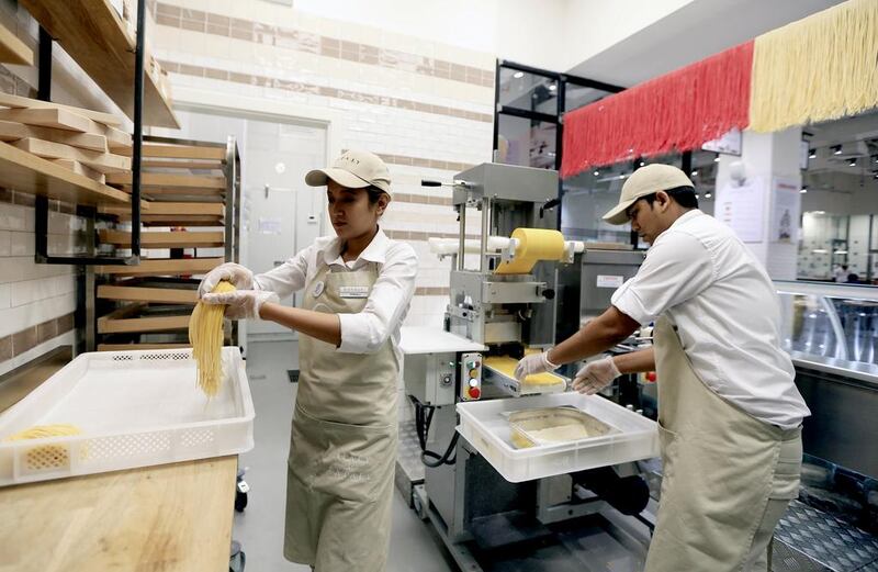 Sharmila Lama, left, and Bighneswor Parida prepare fresh pasta at Eataly. Sarah Dea / The National



