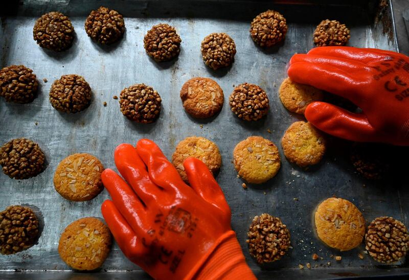 A worker arranges cookies on a tray for delivery at a bakery ahead of the Muslim festival of Eid al-Fitr in Srinagar.   AFP