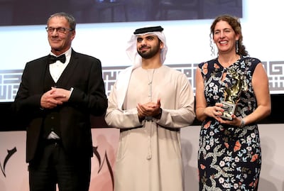 DUBAI, UNITED ARAB EMIRATES - DECEMBER 13:  Director Annemarie Jacir (R) with the Muhr Best Fiction Feature award for "Wajib" with actor Mohammad Bakri (L) and HH Sheikh Mansoor bin Mohammed bin Rashid Al Maktoum at the Muhr Awards on day eight of the 14th annual Dubai International Film Festival held at the Madinat Jumeriah Complex on December 13, 2017 in Dubai, United Arab Emirates.  (Photo by Vittorio Zunino Celotto/Getty Images for DIFF)