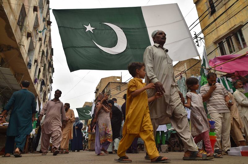 Pakistani flags hang over a market in Karachi selling items in the national colours ahead of the country's 76th Independence Day. EPA