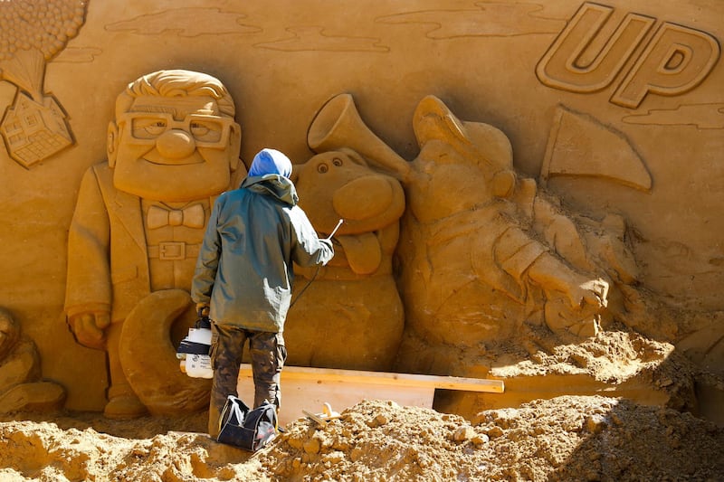 The characters from Disney's 'Up' get worked on by a sand carver. Yves Herman / Reuters