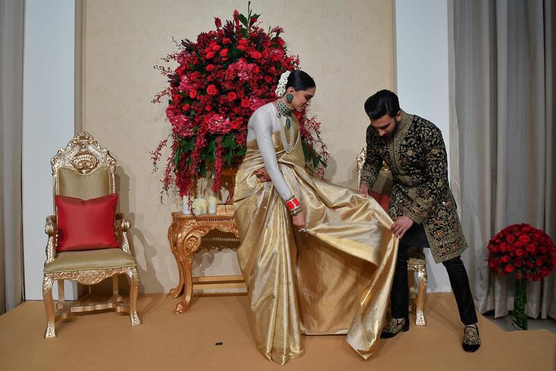 Padukone wore a gold sari by Angadi Galleria, while Singh chose an embroidered sherwani by Rohit Bal. Photo / AFP