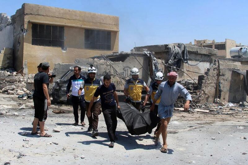 This Thursday, June. 20, 2019 file photo provided by the Syrian Civil Defense White Helmets, which has been authenticated based on its contents and other AP reporting, shows Civil Defense workers and civilians carrying a body after airstrikes by Syrian government forces hit the town of Hish in Idlib province, Syria. Two members of the opposition's Syrian Civil Defense were killed and four were wounded Wednesday, June 26, 2019 when an airstrike struck their ambulance in northwestern Syria as violence claimed more lives in the last major rebel stronghold in the country, the Civil Defense and opposition activists said. (Syrian Civil Defense White Helmets via AP, File)