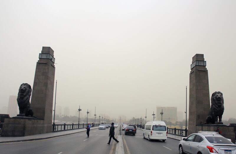 Egyptians walk on Kaser al-Nile bridge during a sandstorm in Cairo. EPA