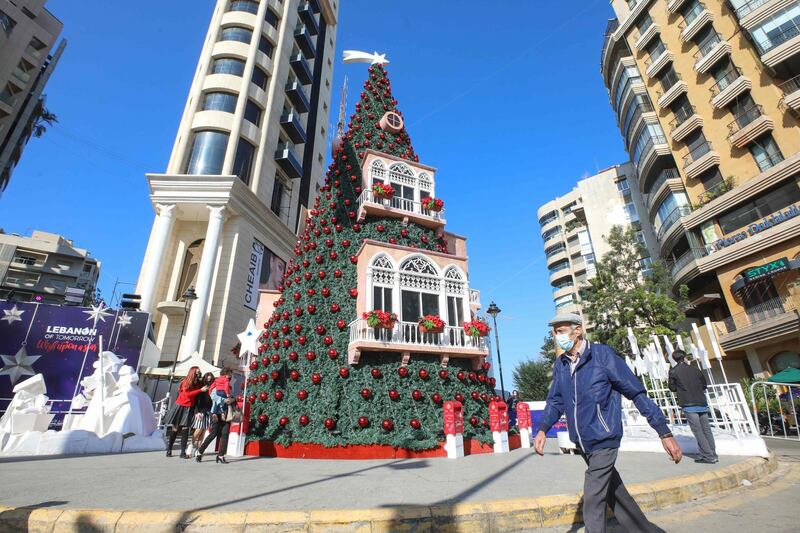 A Lebanese man wearing a protective mask walks past a Christmas tree in Beirut's Achrafieh district. AFP