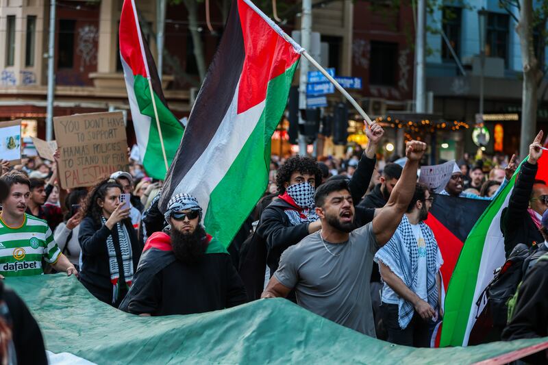 Protesters chant and wave the Palestinian flag at a rally in Melbourne, Australia. Getty Images
