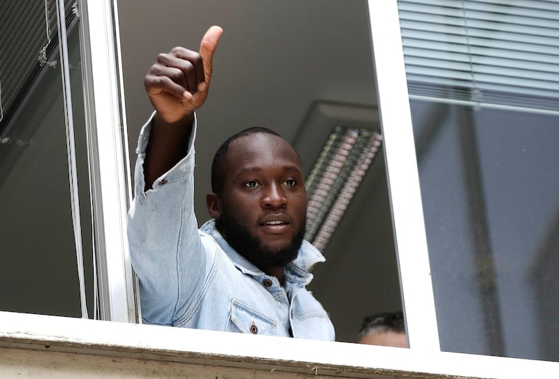 Soccer forward Romelu Lukaku gives his thumbs up as he salutes Inter Milan supporters from a window of the Italian Olympic Committee's headquarters, in Milan,Italy, Thursday, Aug. 8, 2019. Manchester United forward Lukaku is on the verge of completing his move to Inter Milan on the final day of transfers in England. (AP Photo/Luca Bruno)