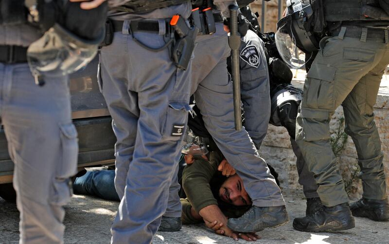 Israeli security forces detain a Palestinian youth during a protest against the March of the Flags, which celebrates the anniversary of Israel's 1967 occupation of the city's eastern sector. AFP