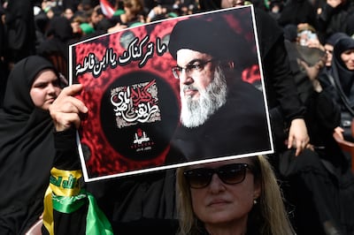 Hezbollah supporter holds a poster with the portrait of leader Hassan Nasrallah. EPA