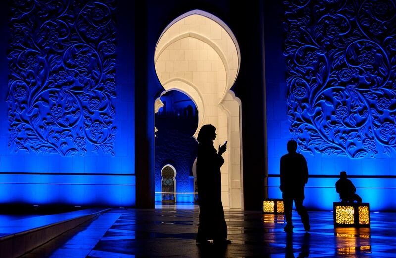 A woman looks at her phone in Sheikh Zayed Grand Mosque in Abu Dhabi. AFP