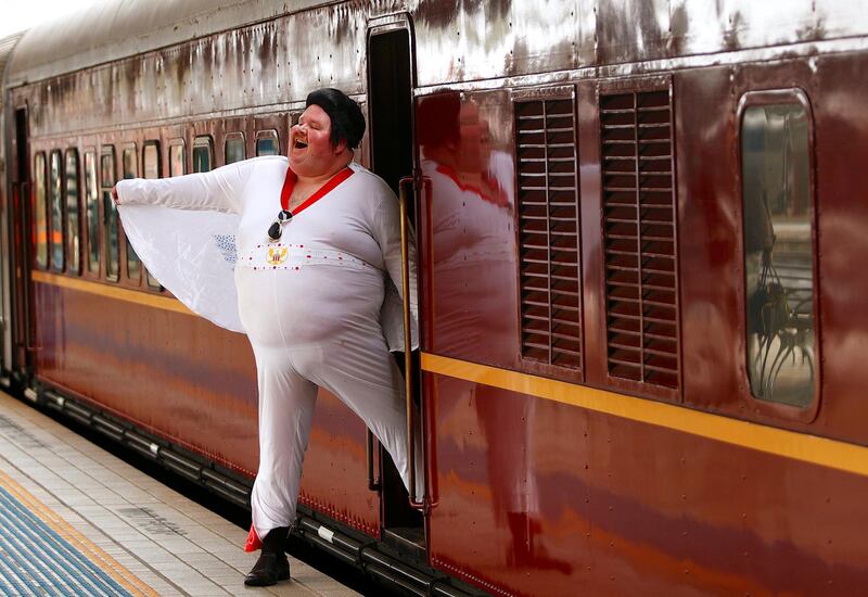 Elvis Presley impersonator Sean Wright poses next to the Elvis Express train at Sydney's Central station before it departs for the 26th annual Elvis Festival. Daniel Munoz / Reuters