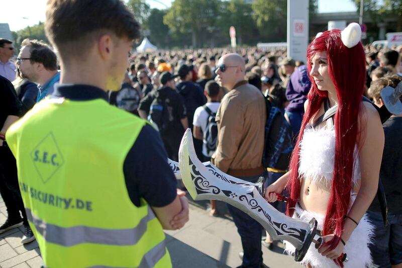 A visitor carrying swords is turned away by a member of security staff at the Gamescom gaming convention. Security was tightened following a spate of attacks in Europe. Oliver berg / EPA