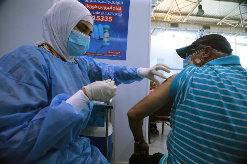 epa09229228 A nurse administers a dose of the COVID-19 vaccine to an elderly man at a mass immunization venue inside Cairo's International Exhibition Center, in Cairo, Egypt, 26 May 2021.  EPA/KHALED ELFIQI