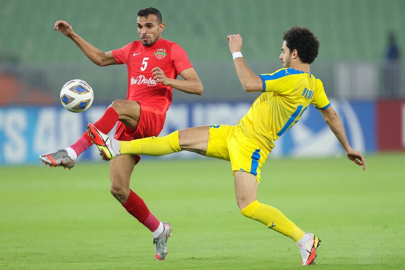Shabab Al Ahli defender Walid Abbas and Al Gharafa forward Ahmed Alaaeldin challenge for the ball. AFP