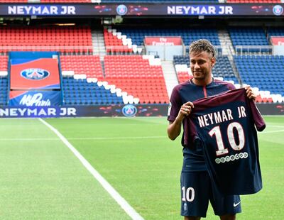 Brazilian superstar Neymar poses with his new jersey during his official presentation at the Parc des Princes stadium on August 4, 2017 in Paris after agreeing a five-year contract following his world record 222 million euro ($260 million) transfer from Barcelona to Paris Saint Germain's (PSG).
Paris Saint-Germain have signed Brazilian forward Neymar from Barcelona for a world-record transfer fee of 222 million euros (around $264 million), more than doubling the previous record. Neymar said he came to Paris Saint-Germain for a "bigger challenge" in his first public comments since arriving in the French capital. / AFP PHOTO / PHILIPPE LOPEZ