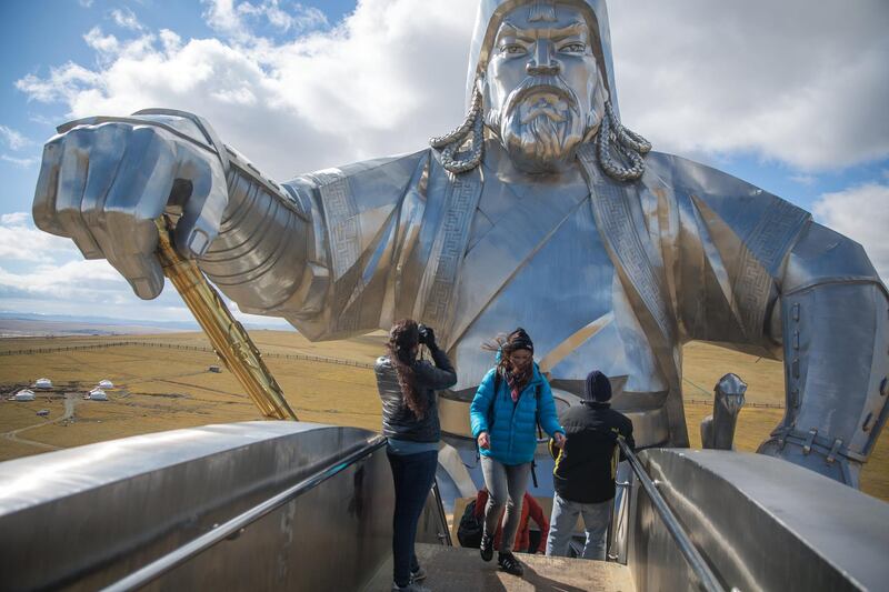 A woman takes a photograph while standing at a viewing area atop the horse of the Genghis Khan Equestrian Statue in Tsonjin Boldog, Mongolia. Taylor Weidman/Bloomberg