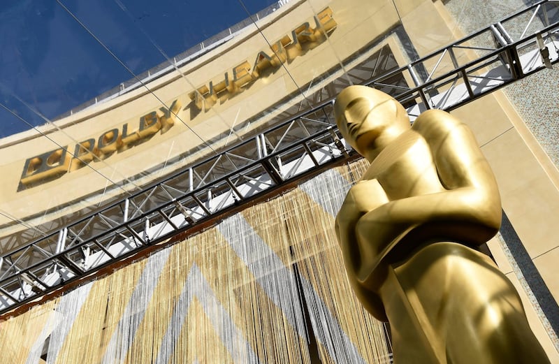 FILE - In this Feb. 24, 2016, file photo, an Oscar statue is pictured underneath the entrance to the Dolby Theatre in Los Angeles. When the Oscars broadcast begins April 25 on ABC, there wonâ€™t be an audience. The base of the show wonâ€™t be the Academy Awardsâ€™ usual home, the Dolby Theatre (though the Dolby will still be involved), but Union Station, the airy, Art Deco-Mission Revival railway hub in downtown Los Angeles. For the producers, the challenges of COVID are an opportunity to, finally, rethink the Oscars. (Photo by Chris Pizzello/Invision/AP, File)