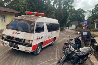 An emergency vehicle drives past as volcanic ash blankets the Indonesian village of Nagari Lasi. AFP