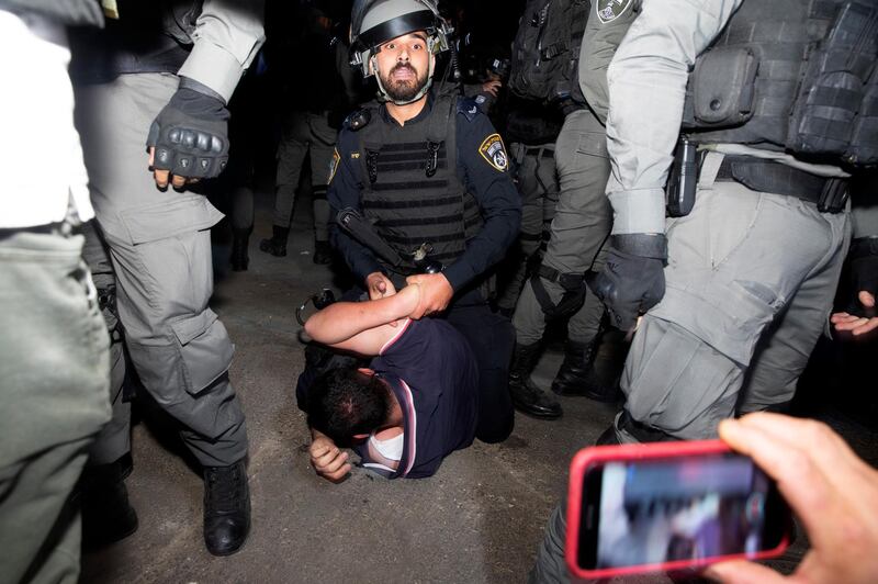 An Israeli police officer restrains a Palestinian during a protest on the eve of a court verdict that may lead to evictiong of Palestinian families from their homes in the Sheikh Jarrah neighbourhood of Jerusalem. AP
