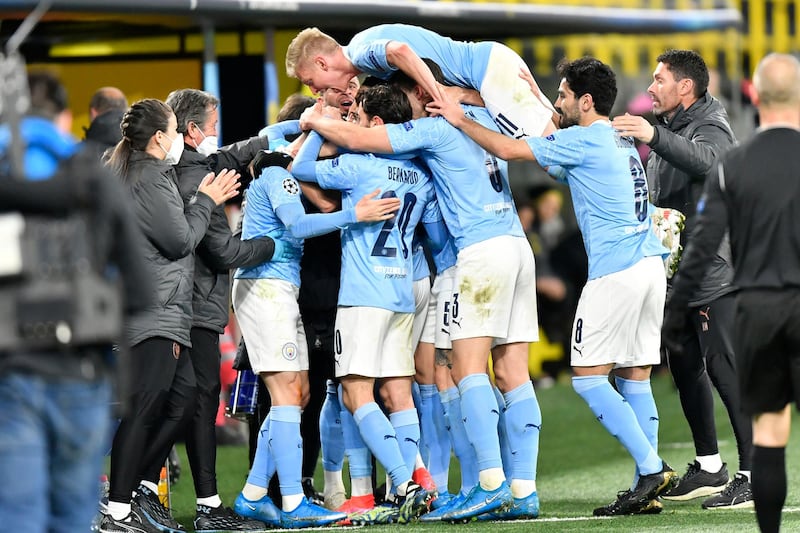 Manchester City manager Pep Guardiola celebrates with goalscorer Phil Foden and team-mates after the winning goal in the Champions League quarter-final against Borussia Dortmund. PA