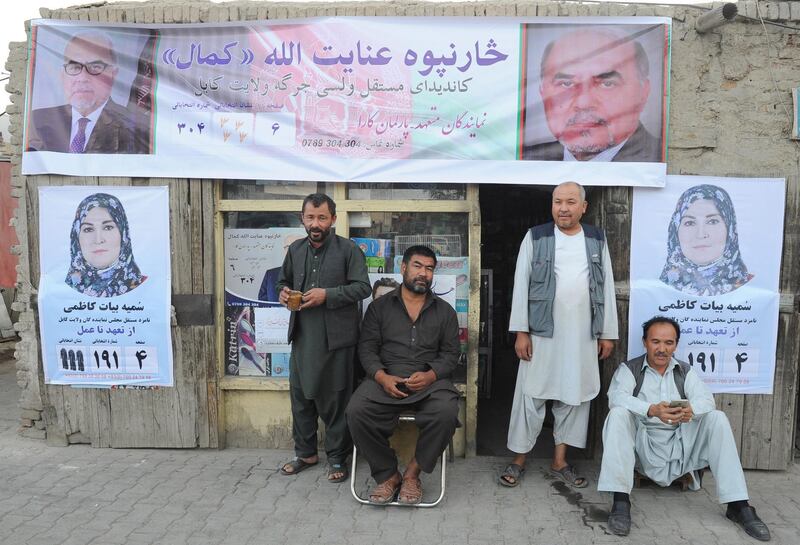 epa07074353 Afghan men sit next to campaign posters of candidates for the upcoming parliamentary on a shop in downtown Kabul, Afghanistan, 06 October 2018. Candidates for the next month's parliamentary vote kicked off their campaign in Afghanistan as the vote for the lower house of parliament is scheduled for 20 October. According to the Independent Election Commission (IEC) around 2,565 candidates are battling for the 249 seats in Wolesi Jirga (Lower House of the Parliament) including 417 women candidates.  EPA/JAWAD JALALI